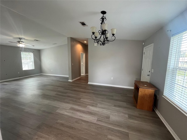 interior space with ceiling fan with notable chandelier and dark hardwood / wood-style flooring