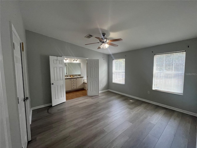 unfurnished bedroom featuring connected bathroom, hardwood / wood-style floors, lofted ceiling, and ceiling fan