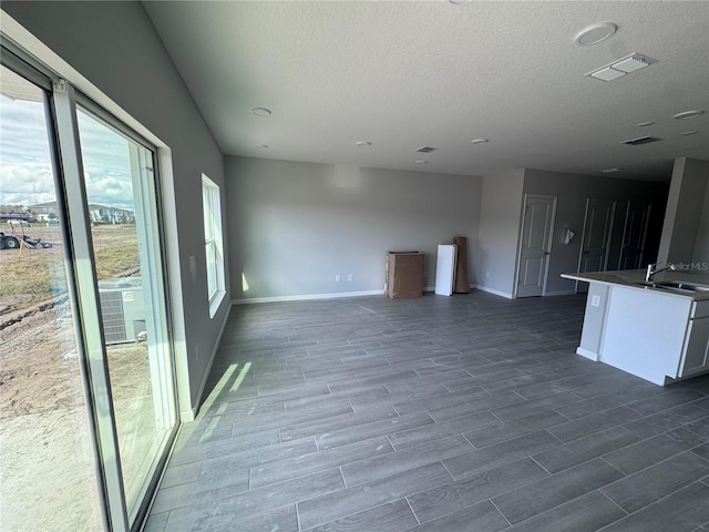 unfurnished living room with sink and a textured ceiling