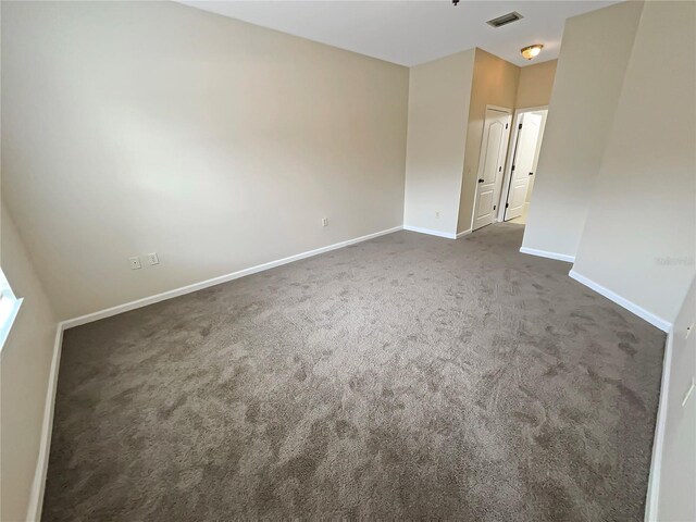 spare room featuring dark colored carpet