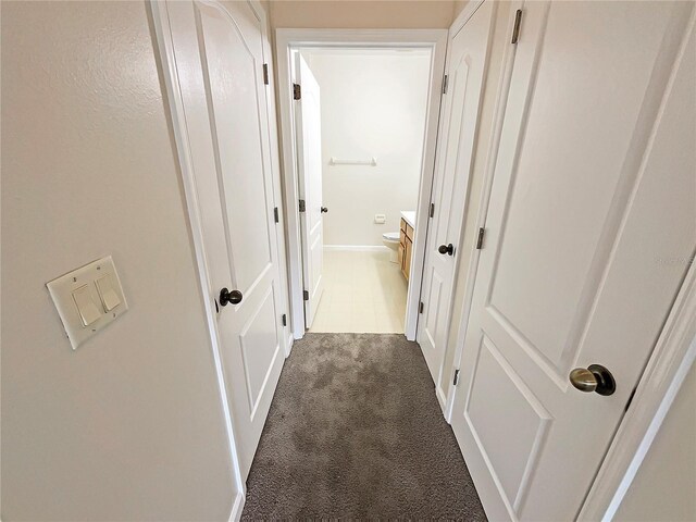 corridor featuring dark colored carpet