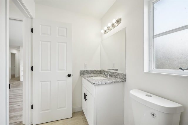 bathroom with vanity, toilet, and hardwood / wood-style floors