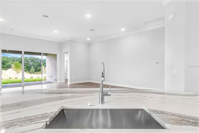 kitchen featuring crown molding, hardwood / wood-style flooring, sink, and light stone countertops