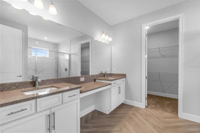 bathroom featuring parquet floors, an enclosed shower, and vanity