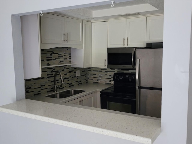 kitchen featuring light stone counters, white cabinets, sink, backsplash, and stainless steel appliances