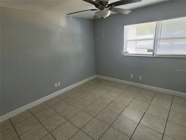 tiled spare room featuring ceiling fan