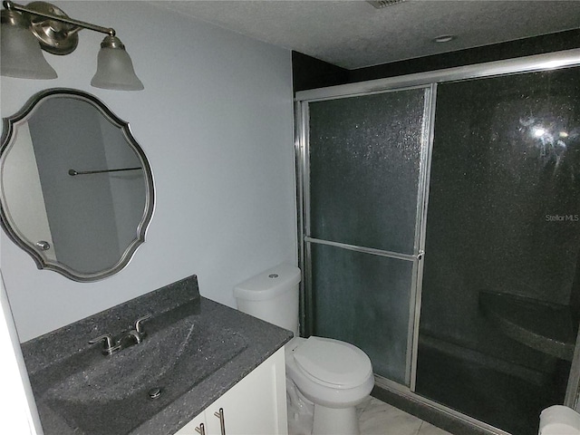 bathroom featuring a textured ceiling, an enclosed shower, vanity, and toilet