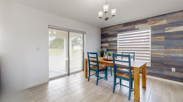 dining area featuring light wood-type flooring, wood walls, and a notable chandelier