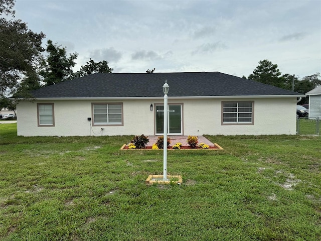 rear view of house featuring a yard