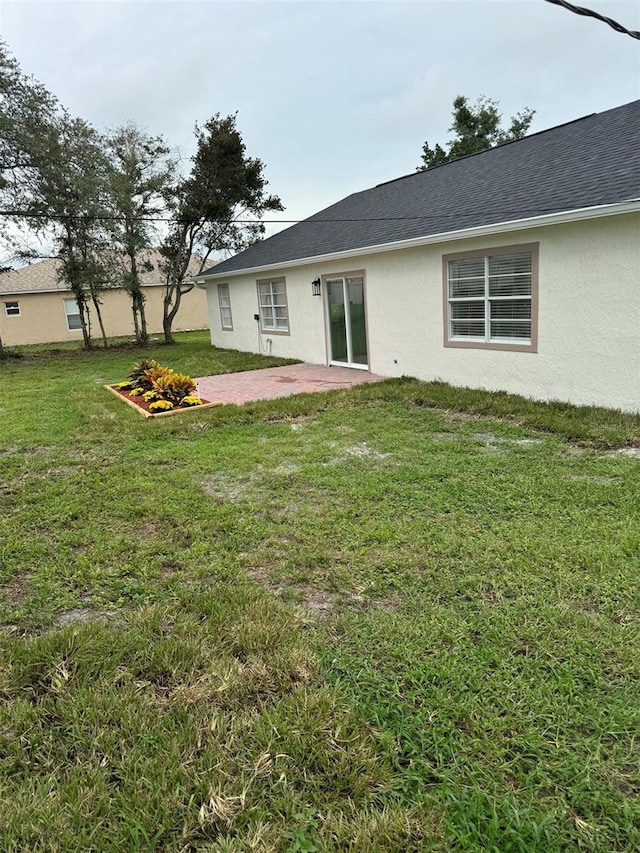 rear view of house featuring a lawn and a patio area