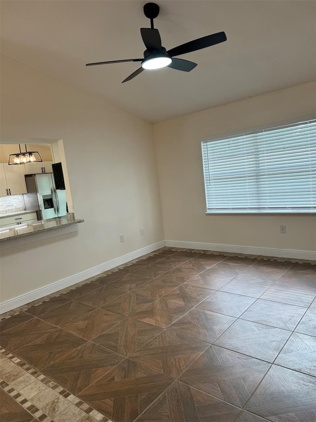 spare room featuring ceiling fan and dark parquet flooring