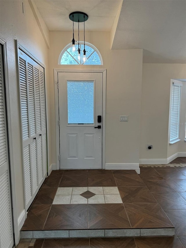 foyer featuring dark parquet floors and a notable chandelier