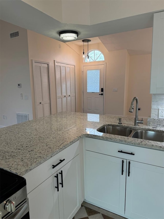 kitchen featuring white cabinets, light stone countertops, sink, and tasteful backsplash