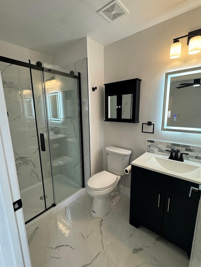 bathroom featuring vanity, toilet, and a shower with shower door