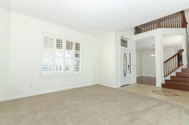 empty room featuring light carpet and a notable chandelier