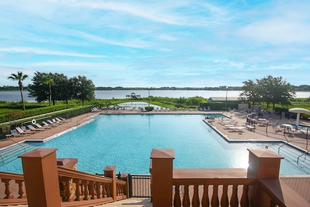 view of pool with a water view and a patio area