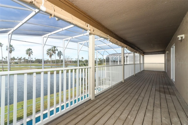 deck with glass enclosure and a water view