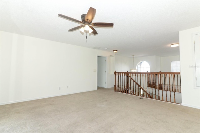 carpeted spare room with a textured ceiling and ceiling fan