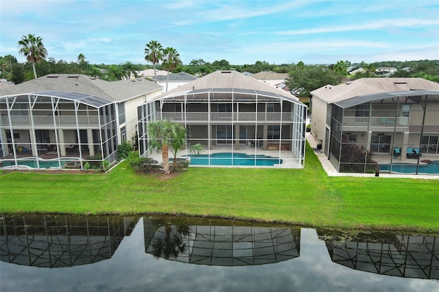 back of property featuring glass enclosure and a yard