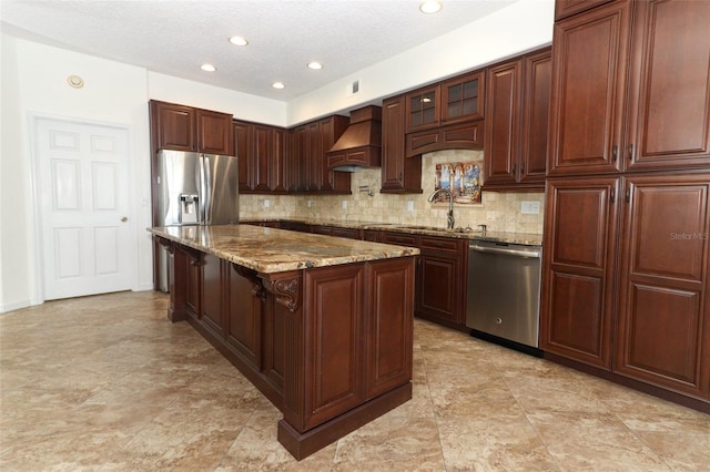 kitchen featuring sink, premium range hood, a kitchen breakfast bar, stainless steel appliances, and a center island