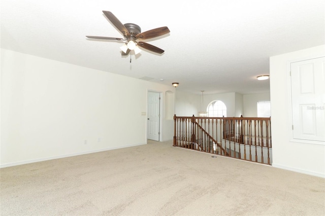 carpeted empty room with ceiling fan and a textured ceiling