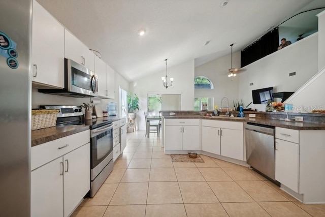 kitchen with stainless steel appliances, pendant lighting, high vaulted ceiling, and white cabinetry