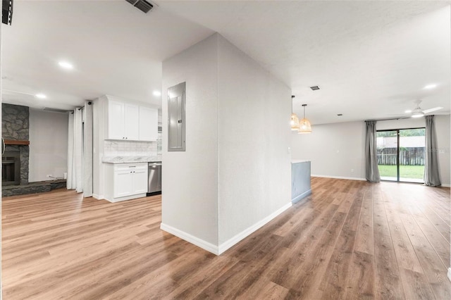 interior space with a fireplace, light wood-type flooring, ceiling fan with notable chandelier, and electric panel