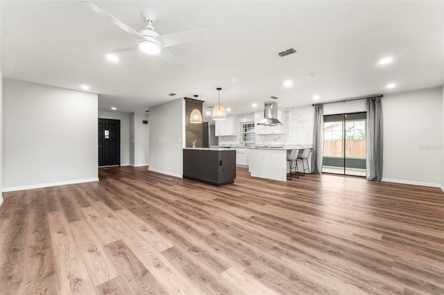 unfurnished living room with wood-type flooring and ceiling fan