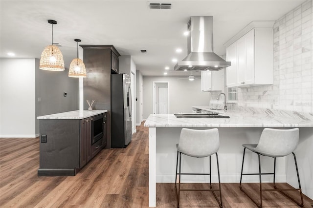 kitchen with appliances with stainless steel finishes, white cabinetry, sink, dark hardwood / wood-style floors, and exhaust hood