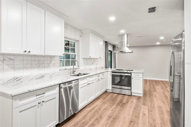 kitchen with light wood-type flooring, white cabinetry, island exhaust hood, sink, and appliances with stainless steel finishes