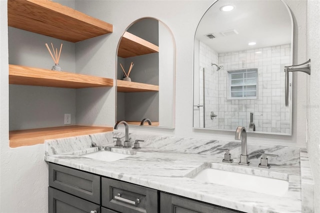 bathroom with vanity and a tile shower