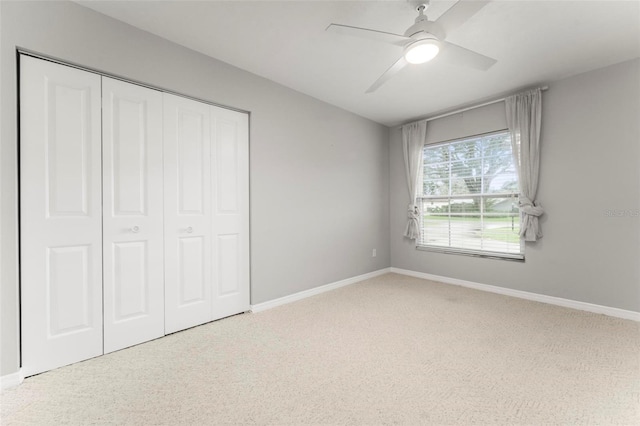 unfurnished bedroom featuring light carpet, ceiling fan, and a closet