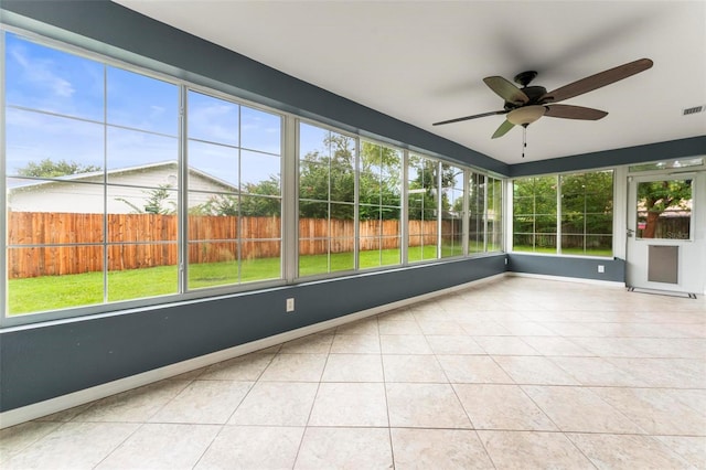 unfurnished sunroom featuring a healthy amount of sunlight and ceiling fan