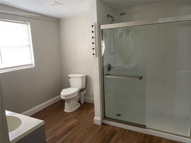 bathroom featuring vanity, toilet, hardwood / wood-style floors, and walk in shower