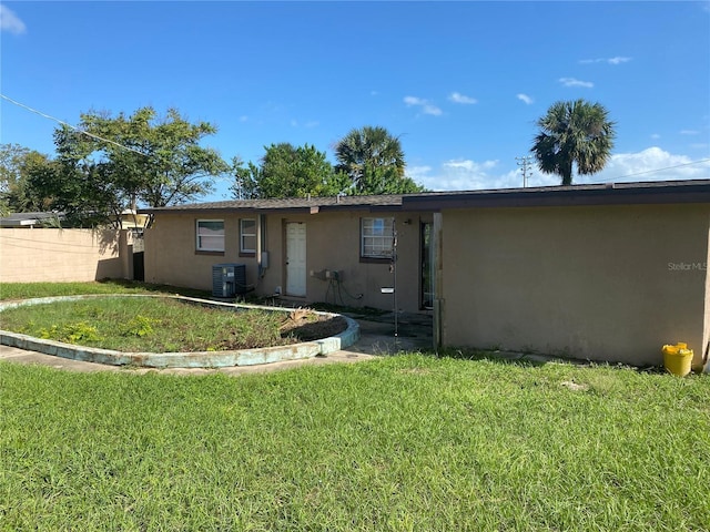 view of front of house with central AC and a front yard