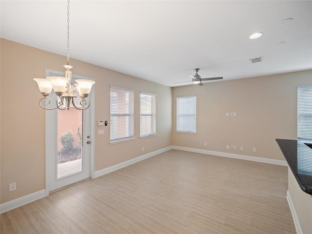 unfurnished living room featuring light hardwood / wood-style floors and ceiling fan with notable chandelier