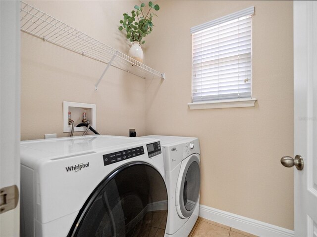 laundry room featuring washing machine and dryer and light tile patterned floors