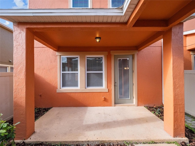 view of exterior entry with a patio