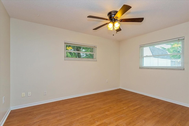 empty room with ceiling fan, a textured ceiling, and light hardwood / wood-style floors