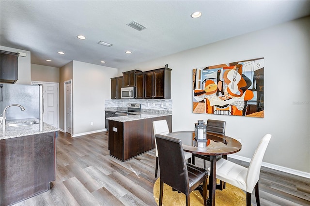 dining room featuring light wood-type flooring and sink