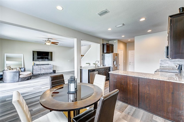 dining space featuring ceiling fan, a textured ceiling, light hardwood / wood-style flooring, and sink