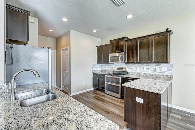 kitchen with dark brown cabinets, stainless steel appliances, and sink