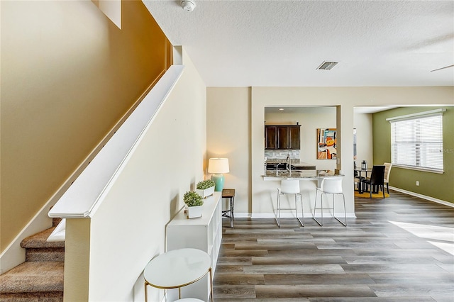 staircase with a textured ceiling and hardwood / wood-style flooring