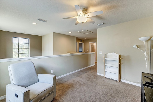 sitting room with a textured ceiling, ceiling fan, and light colored carpet