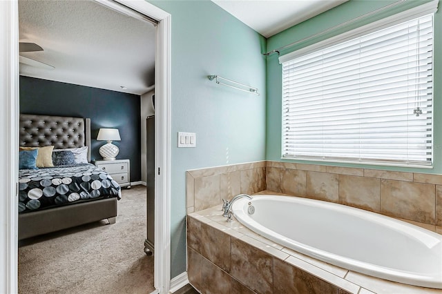 bathroom featuring a textured ceiling and tiled tub