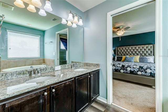 bathroom featuring wood-type flooring, ceiling fan, vanity, and a bathtub