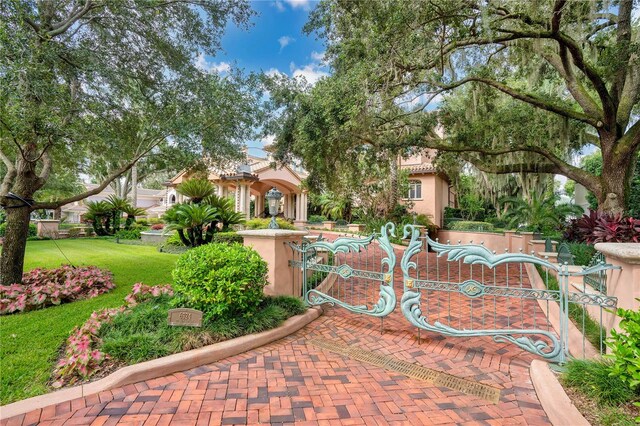 view of front of house featuring a gate, a front lawn, and stucco siding