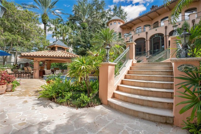 view of community with stairs, a gazebo, and a patio area