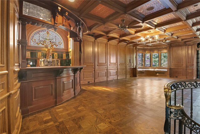 interior space featuring coffered ceiling, a decorative wall, wooden walls, and beamed ceiling