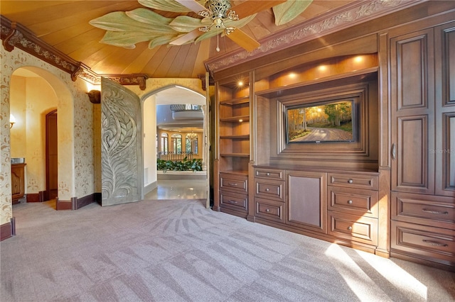 interior space with arched walkways, wood ceiling, built in features, ornamental molding, and carpet